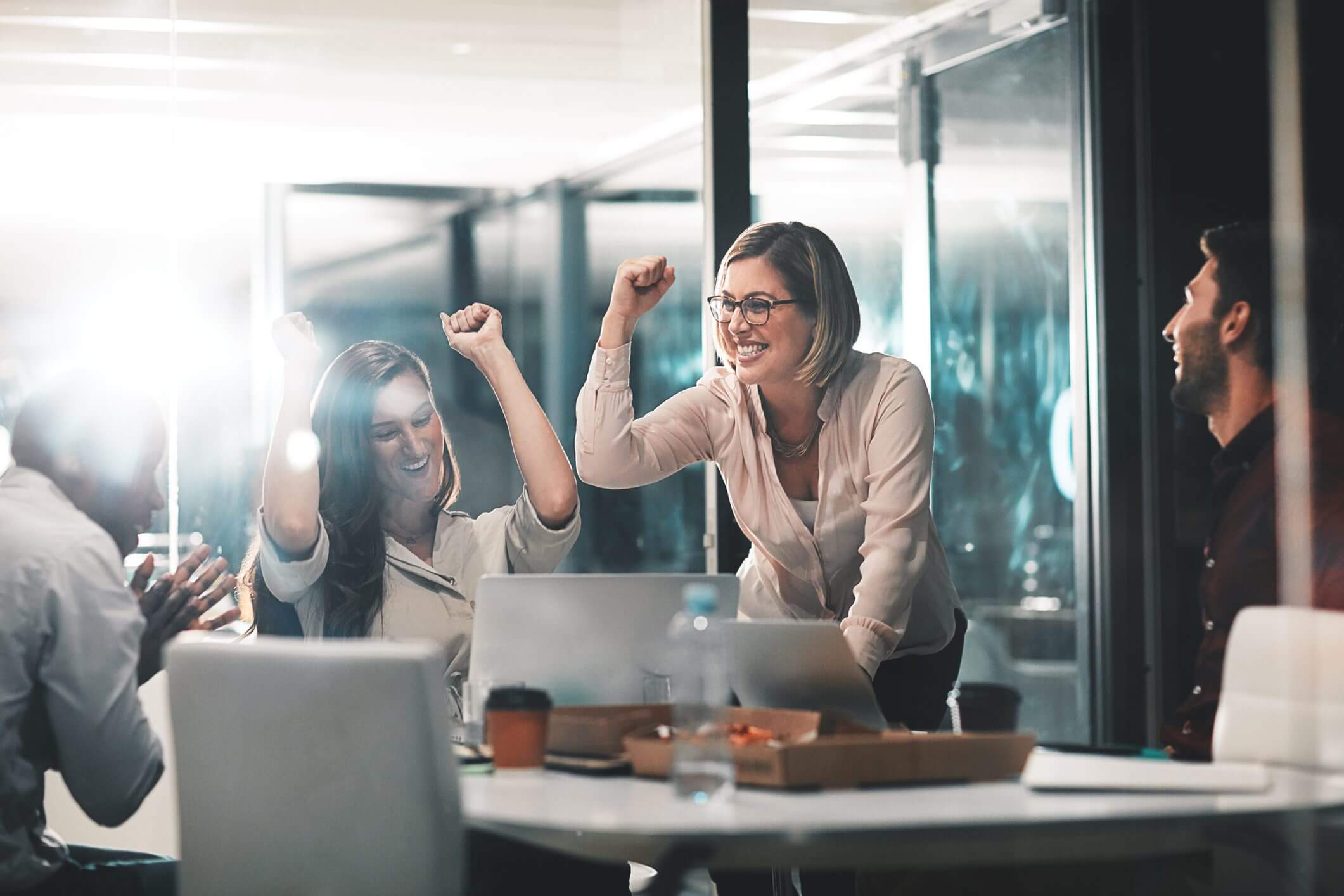 A joyful woman celebrating success in an office setting.