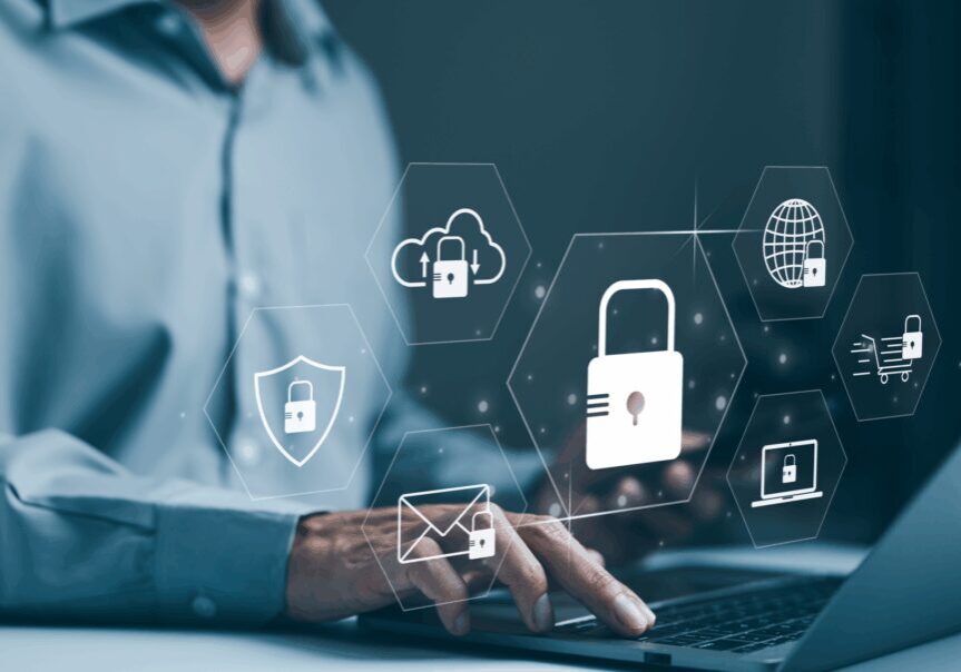 Person using laptop with security icons overlay.